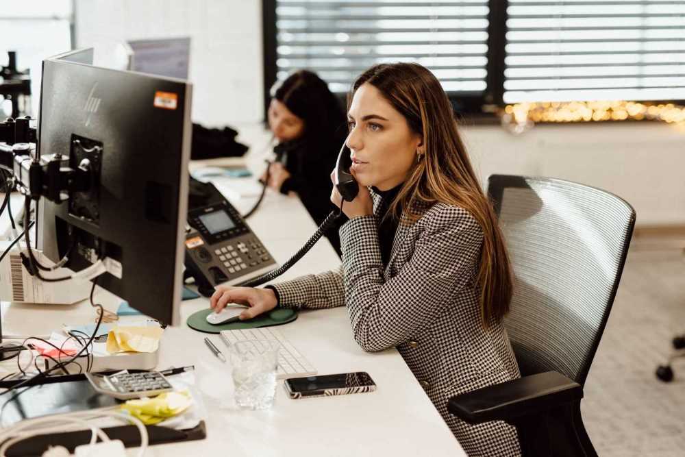 werknemer Trias Legal die aan een bureau zit te bellen