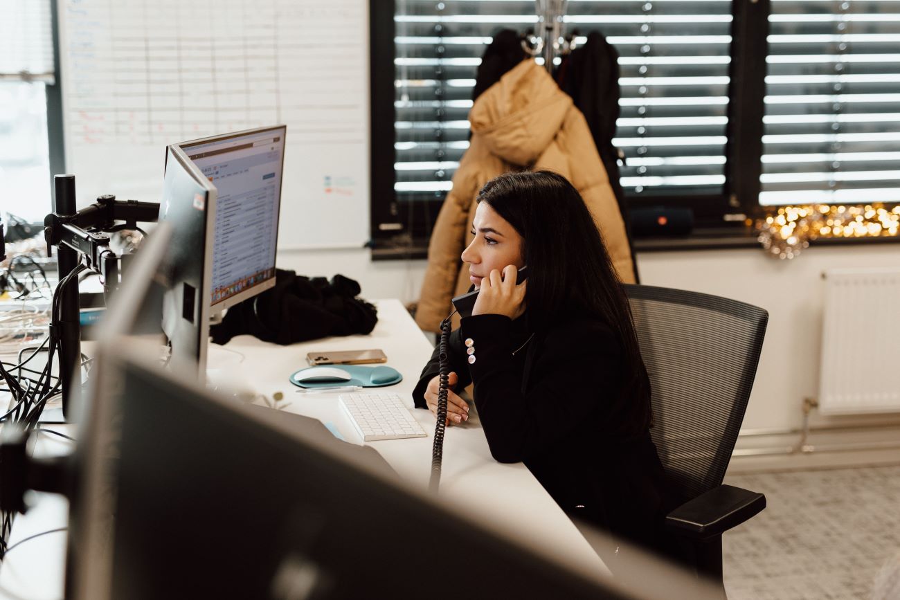 vrouw met lang stijl haar aan de telefoon in een kantooromgeving